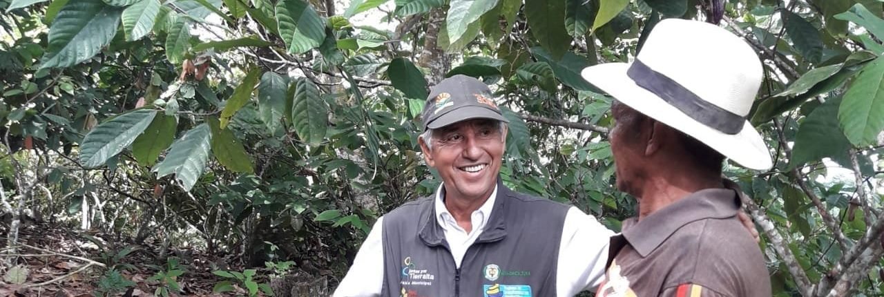 Un técnico agropecuario conversa con un campesino en un cultivo del Chocó
